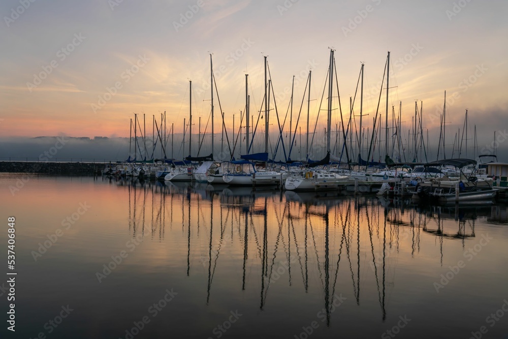 Sailboat reflections in a misty pink sunrise