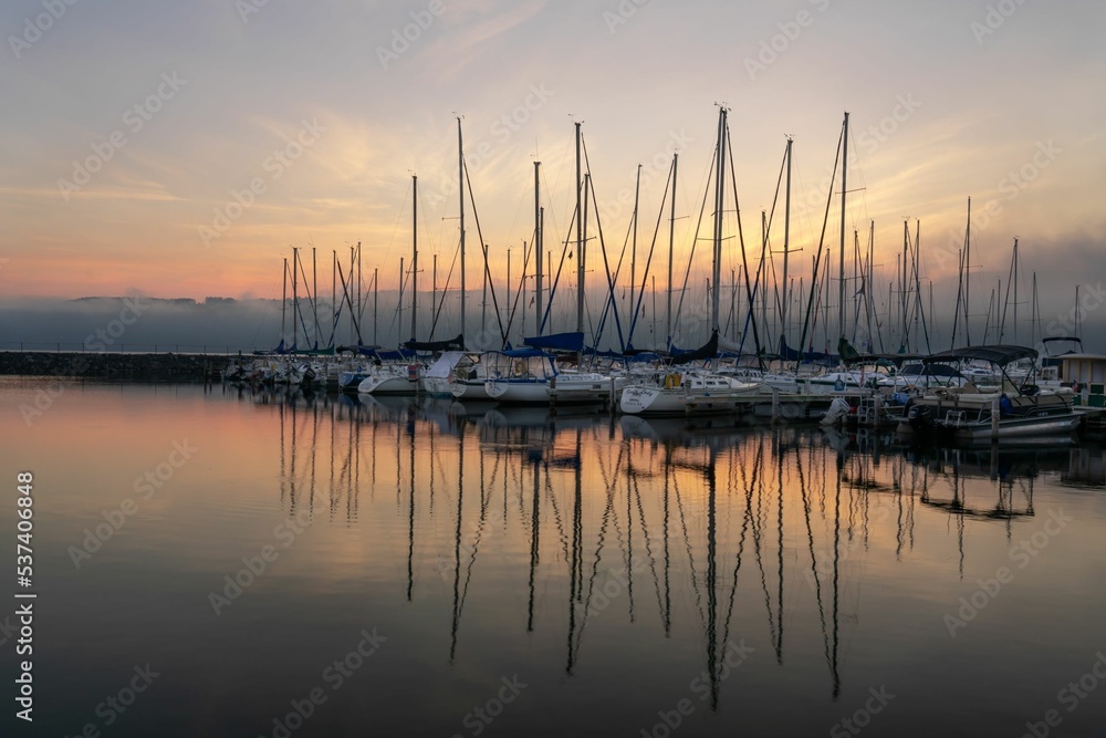 Sailboat reflections in a misty pink sunrise Sailboat reflections in a misty pink sunrise