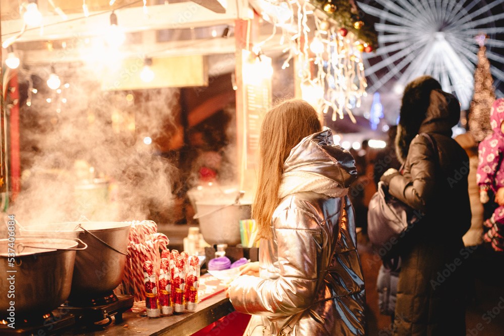 Young woman standing by food court at Christmas market in city
