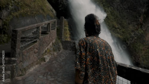 Back View Of A Person Walking On The Viewing Balcony At Devil's Cauldron Waterfall In Rio Verde, Banos Ecuador. photo