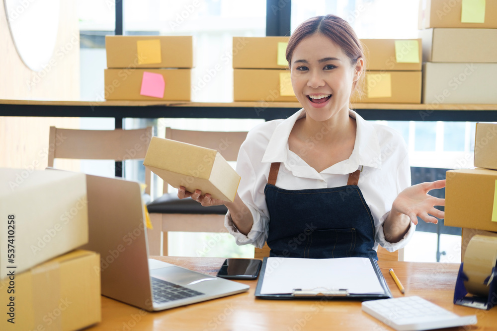 Female online business owner happy and showing delivery boxes. Female online business owner happy and showing delivery boxes.