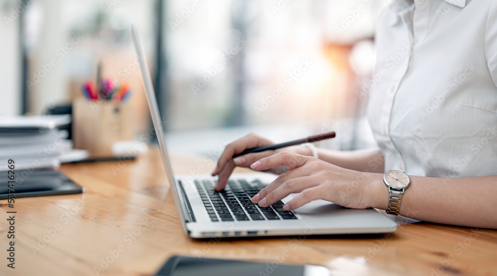 Woman hand typing on laptop keyboard, young businesswoman working on laptop sitting at home office. Woman hand typing on laptop keyboard, young businesswoman working on laptop sitting at home office.