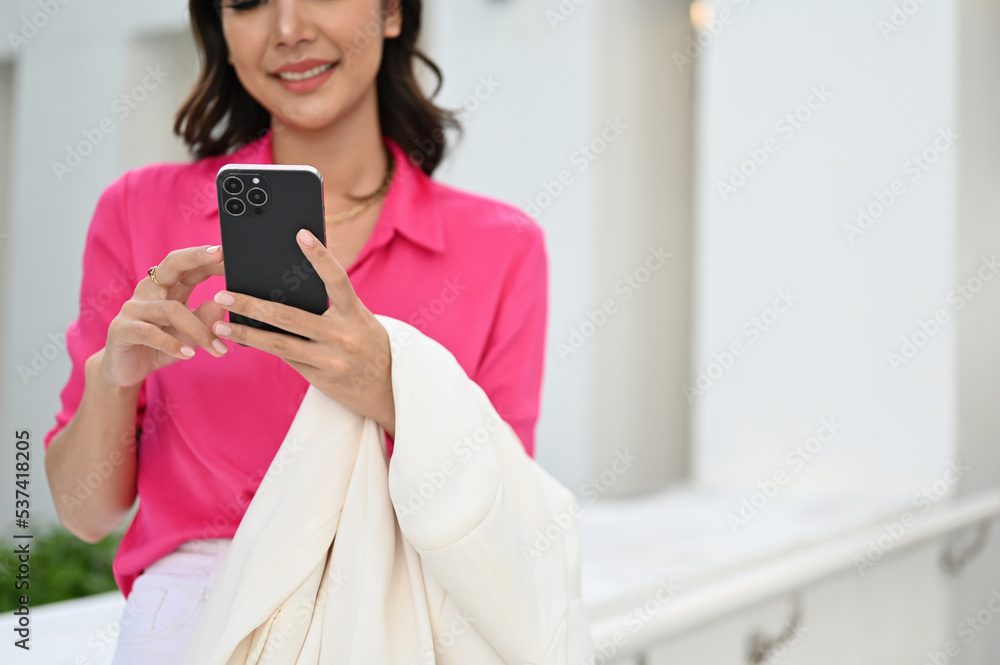 Elegant Asian businesswoman chatting with her business partner on her smartphone. Elegant Asian businesswoman chatting with her business partner on her smartphone.
