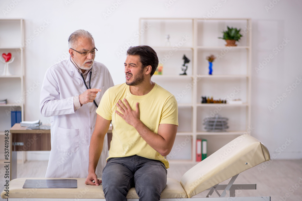 Young male patient visiting old male doctor Young male patient visiting old male doctor