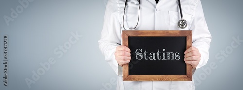 Statins. Doctor shows term on a wooden sign. photo