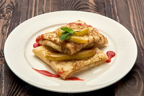 delicious juicy pancakes drizzled with sauce are served on a white plate