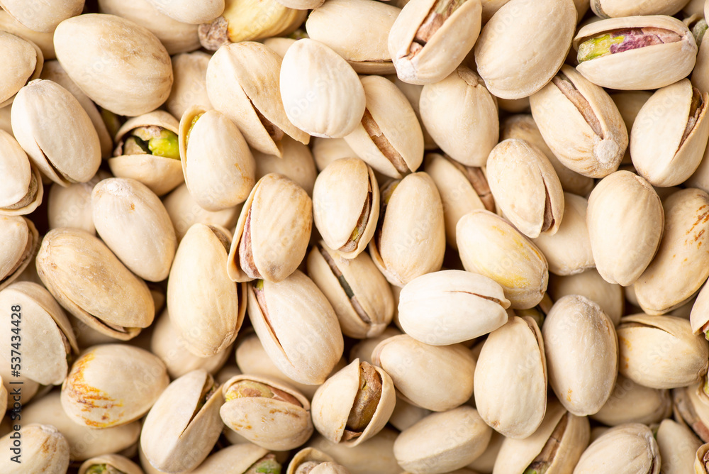 Pistachio background. Many taste pistachios with salt ready to be eaten Pistachio background. Many taste pistachios with salt ready to be eaten