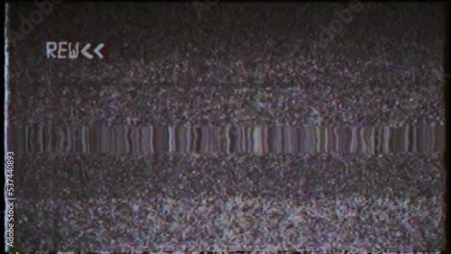 An overlay featuring a black and white VHS rewind effect and noise.