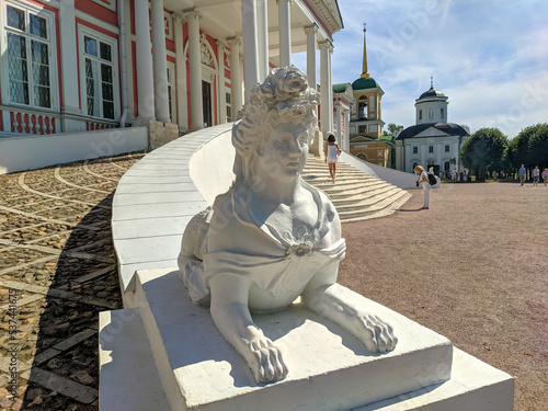 Moscow, Russia - August 13, 2022: View of the Kuskovo Palace, the former estate of the Sheremetevs in the Kuskovo estate museum. Large white sphinx is installed near the entrance to the palace photo