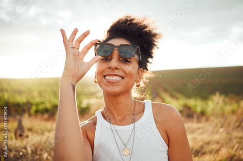Fotografie Young black woman, sunset portrait in field countryside and happy smile with summer sunglasses in Brazil