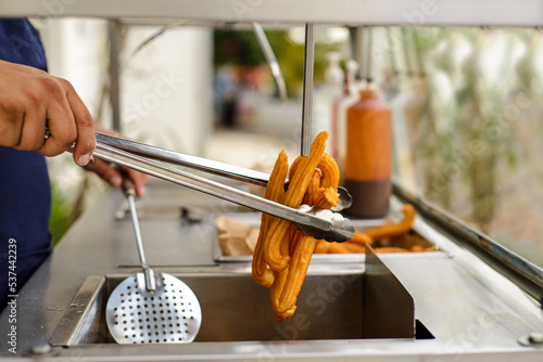 Foto Elaboration of churros in a street stall.