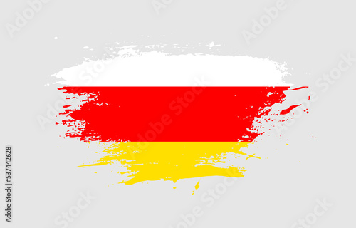 Grunge brush stroke with the national flag of South Ossetia on a white isolated background