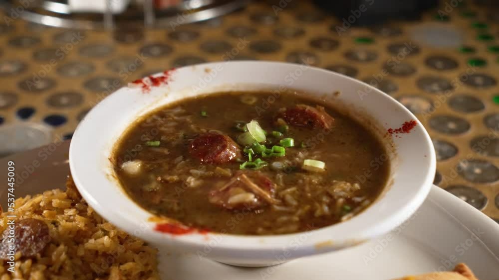Traditional cajun chicken sausage gumbo topped with green onions and file seasoning, slider 4K Traditional cajun chicken sausage gumbo topped with green onions and file seasoning, slider 4K
