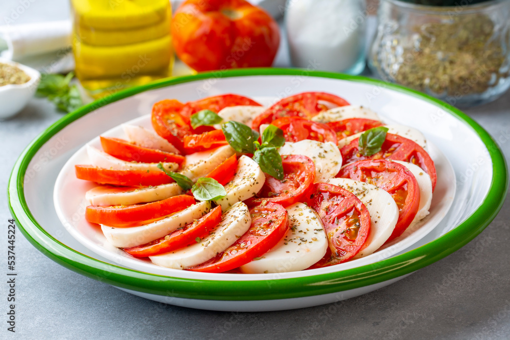 Italian caprese salad with sliced tomatoes, mozzarella, basil, olive oil Italian caprese salad with sliced tomatoes, mozzarella, basil, olive oil