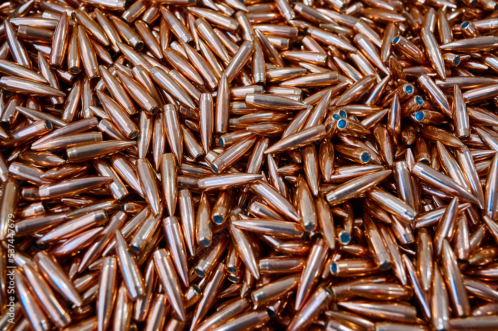 Glowing large caliber bullet heap for riffle as background Glowing large caliber bullet heap for riffle as background