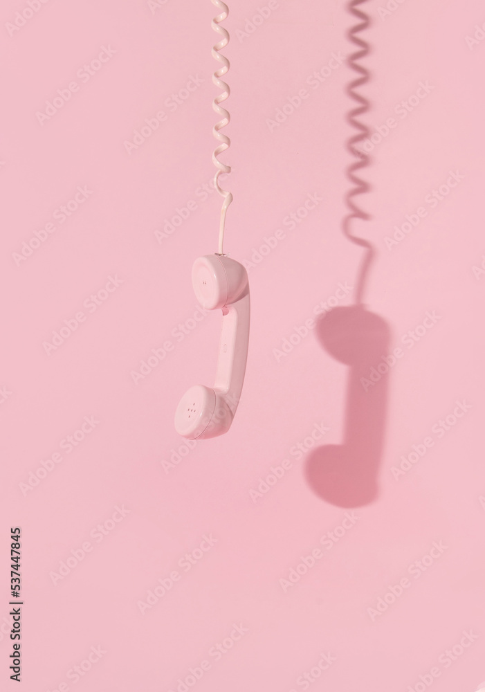 Creative layout with pink retro phone handset on pastel pink background ...