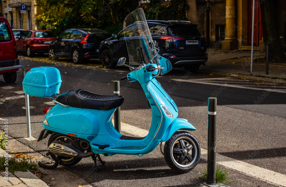 Niebieski skuter na poznańskiej ulicy w Polsce. 