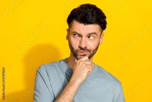 Portrait photo of young funny man touch chin pouted lips unhappy look empty space advertisement distust offer isolated on yellow color background © deagreez