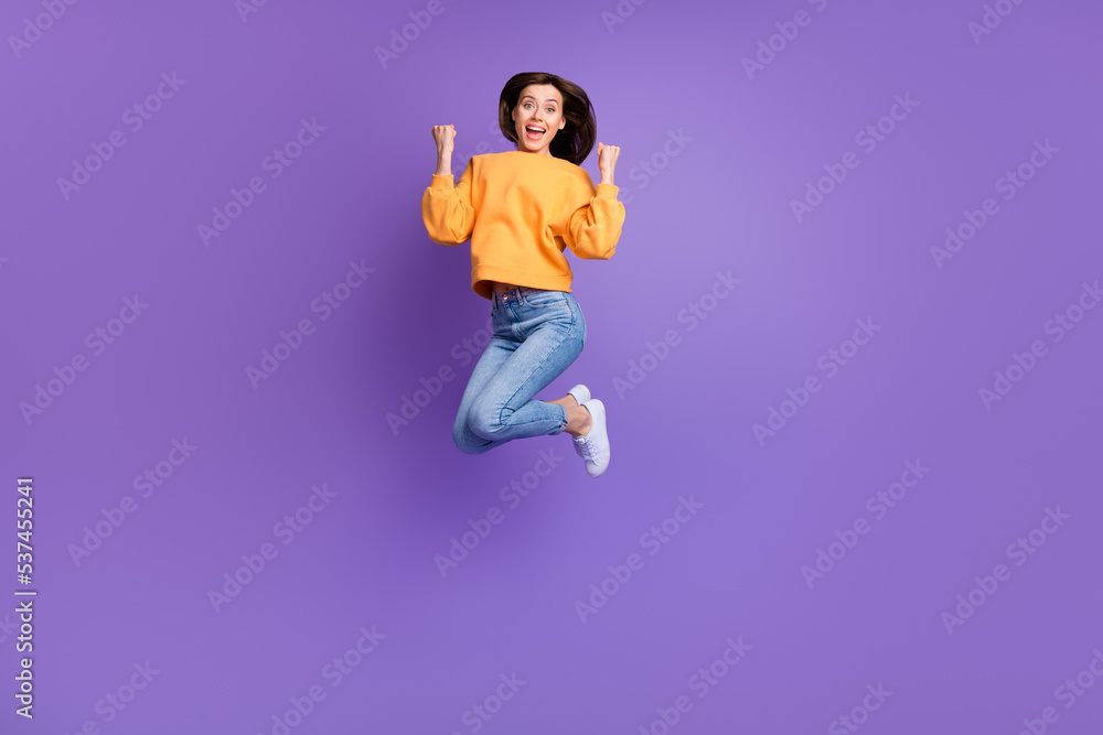 Full size photo of charming crazy jumper woman active sportive fists up celebrate hooray triumphant finally result isolated on purple color background Full size photo of charming crazy jumper woman active sportive fists up celebrate hooray triumphant finally result isolated on purple color background