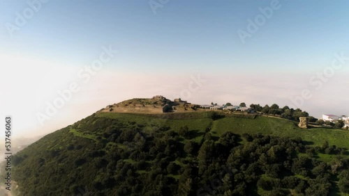 Aerial rotating drone shot over the mountains of medina sidonia in andalucia spain under blue sky during a sunny day overlooking the landscape. Cádiz photo