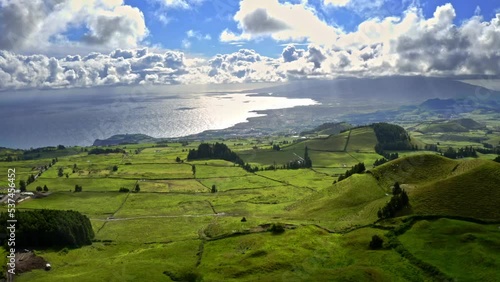 Dreamland countryside with hills, green pastures and clouds, aerial. photo