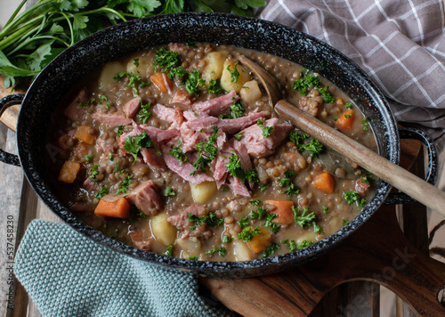 Lentil stew with pork meat in a rustic pot