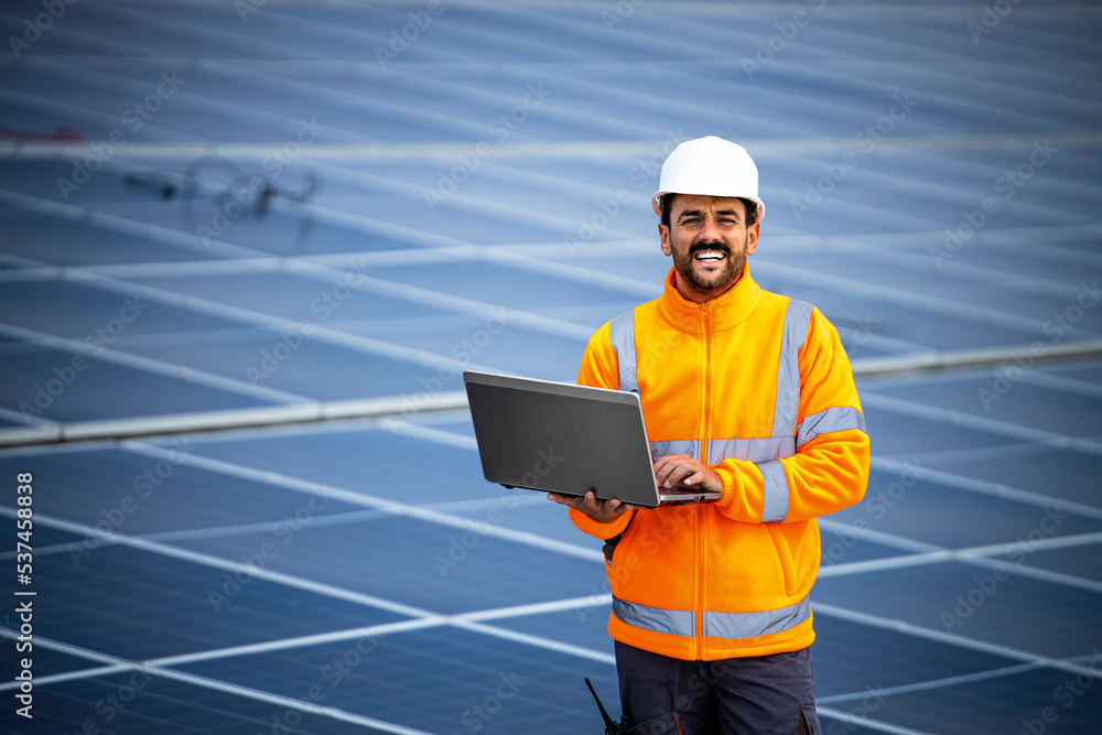 Portrait of solar power plant engineer with laptop computer controlling sustainable energy production. Portrait of solar power plant engineer with laptop computer controlling sustainable energy production.