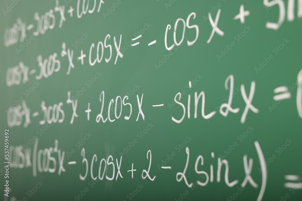 Many different math formulas written on green chalkboard, closeup Many different math formulas written on green chalkboard, closeup