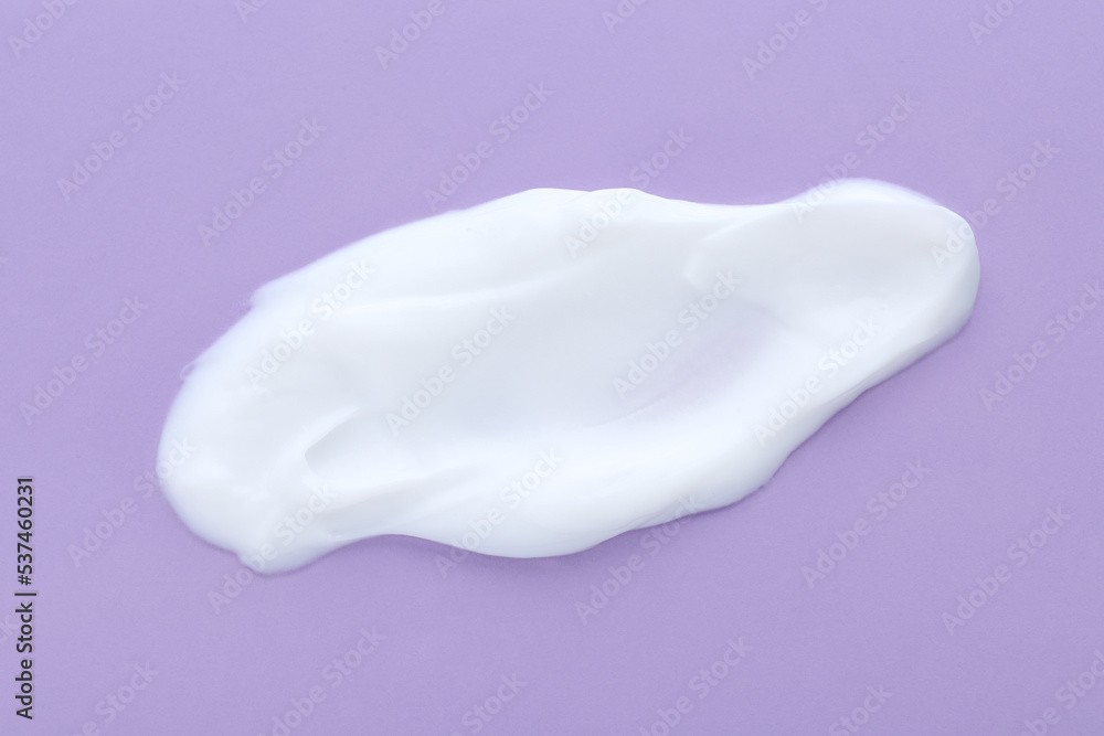 Sample of body cream on lilac background, closeup