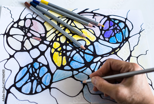 Abstract neurographic drawing. A woman draws a neurographic drawing on paper with color pencils. Neurographic art-an easy way to work with the subconscious mind through drawing.Taking care of yourself