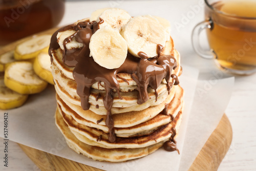 Tasty pancakes with sliced banana served on white table, closeup