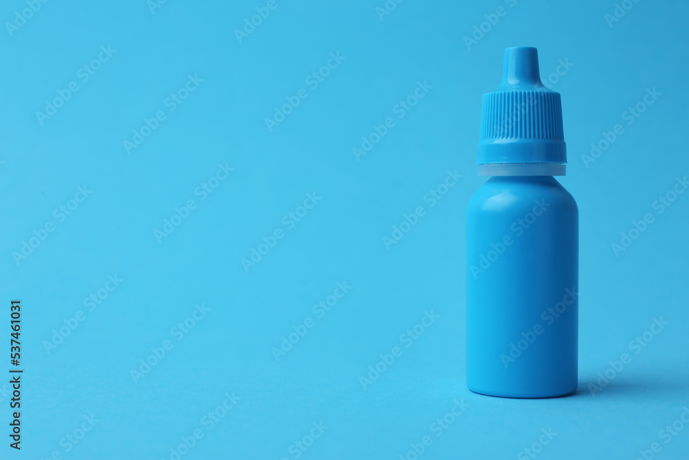 Bottle of medical drops on light blue background. Space for text Bottle of medical drops on light blue background. Space for text