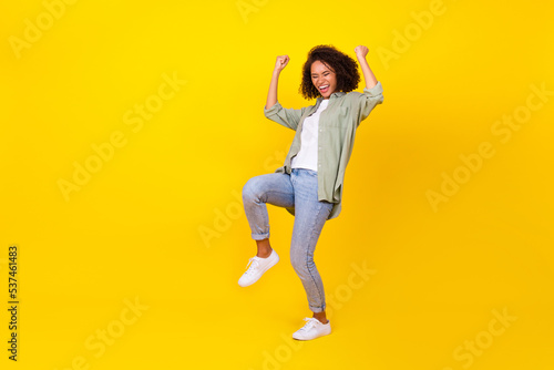 Full length photo of nice young lady curly hair celebrate job promotion sales wear trendy khaki look isolated on yellow color background