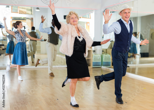 Photography Man and elderly woman performing jazz dance in dancing room