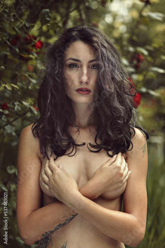 Beautiful young woman in roses garden