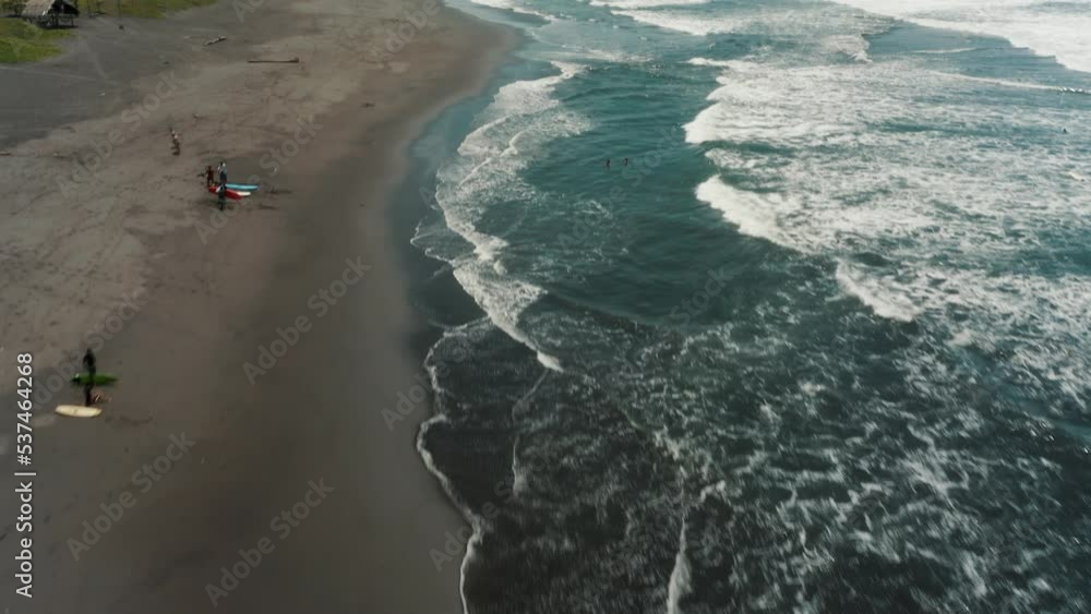 Surfers On The Shore Of El Paredon Beach A Surf Destination Of Guatemala. Aerial Drone Shot Surfers On The Shore Of El Paredon Beach A Surf Destination Of Guatemala. Aerial Drone Shot