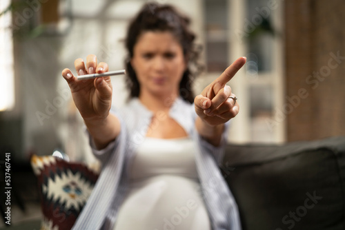 Фотография Beautiful pregnant woman refuses to smoke cigarette