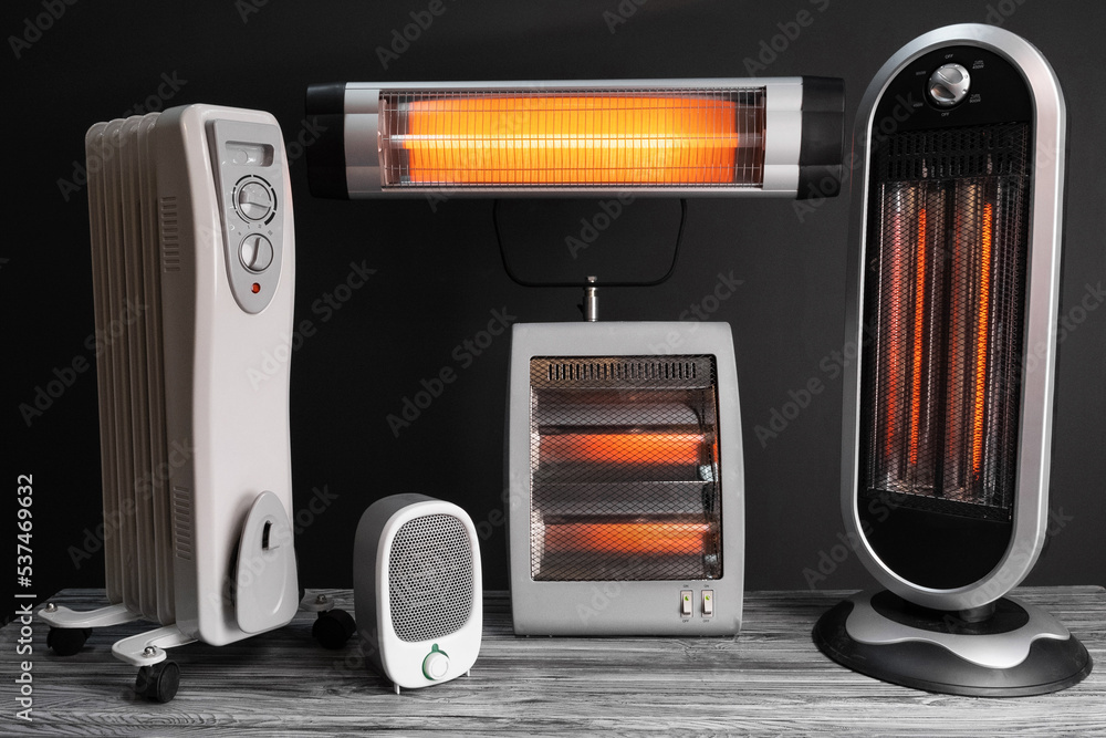 Modern electric infrared, oil and fan heater in living room