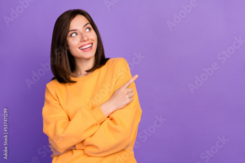 Close up photo of lovely satisfied lady trendy orange sweater arm direct empty space cool proposition isolated on purple color background © deagreez