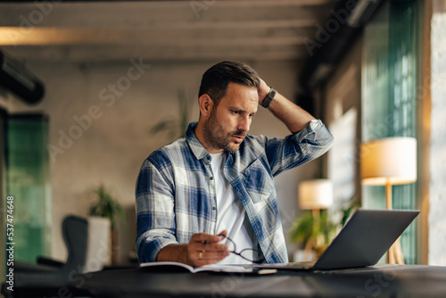 Businessman having a trouble at work, using a laptop, working on