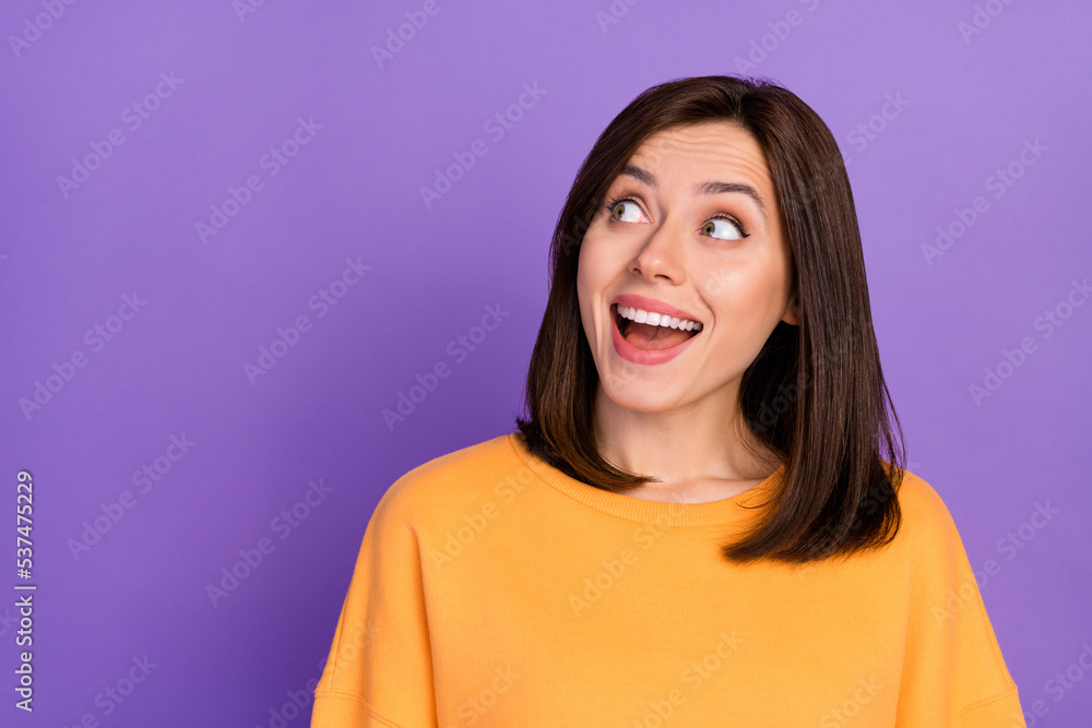 Closeup photo of young millennial girl wear orange sweatshirt look intersted empty space advertisement shopping isolated on purple color background