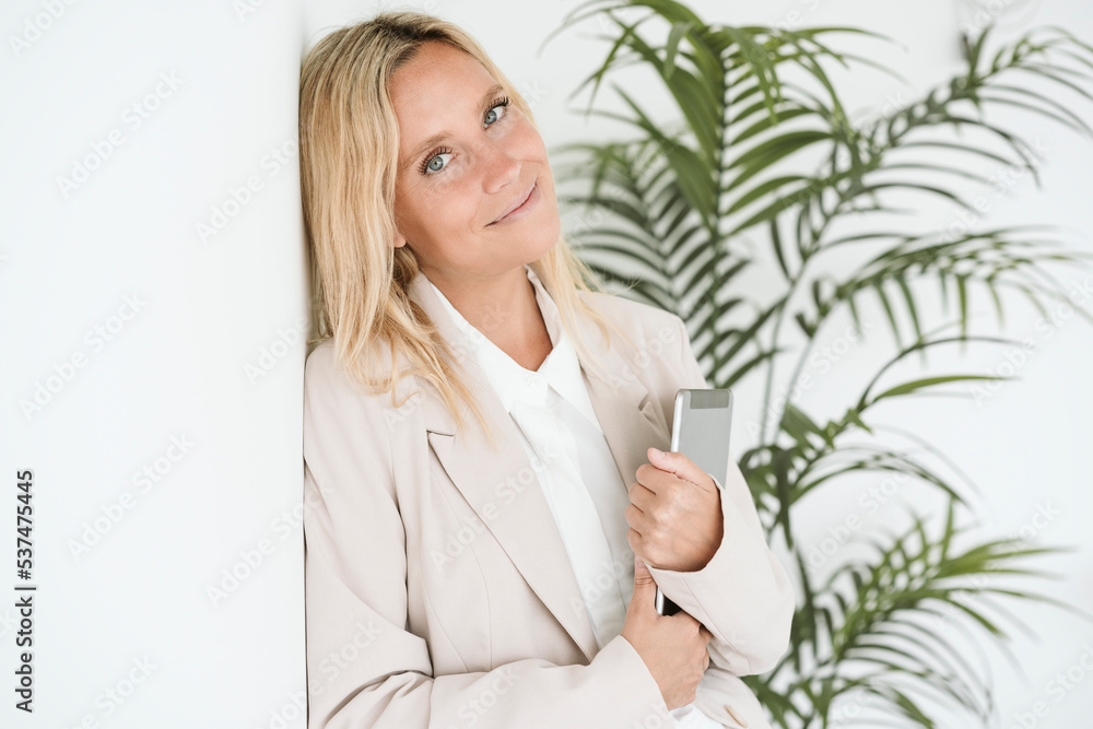 Portrait of businesswoman leaning against wall holding tablet PC Portrait of businesswoman leaning against wall holding tablet PC