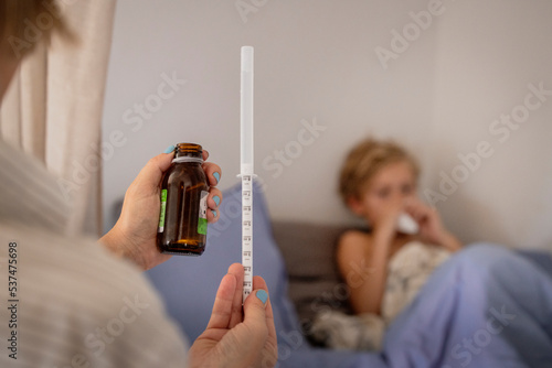 Mother applying medicine to sick boy photo