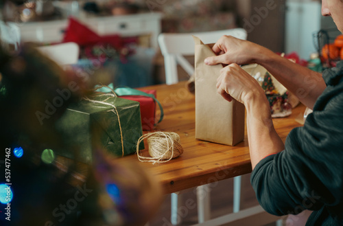 Man wrapping Christmas gift with craft paper. Christmas or New year DIY packing Concept. 