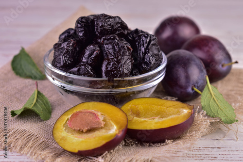 Dried plums or prunes and fresh plums in a bowl.Close-up.
