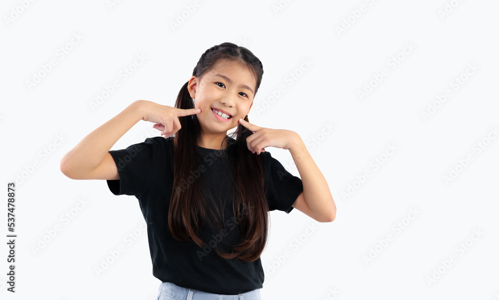 Asian cute girl in black t-shirt posing finger pointing on cheek smiling on white background. Asian cute girl in black t-shirt posing finger pointing on cheek smiling on white background.