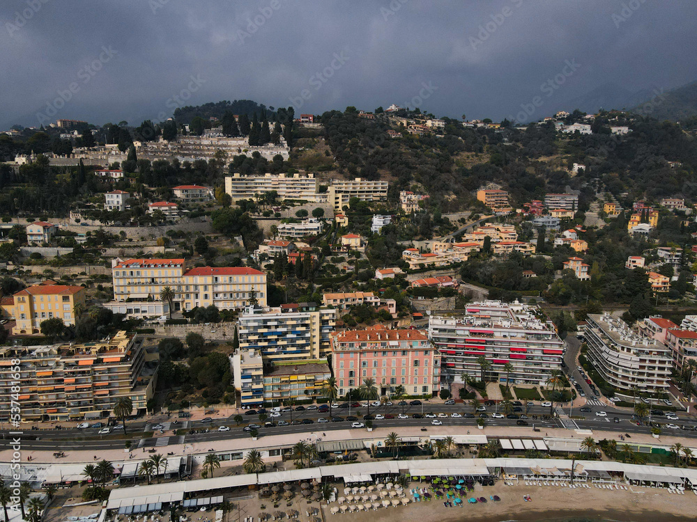 Aerial view of Menton in French Riviera from above. Drone view of France Cote d'Azur sand beach beneath the colorful old town of Menton. Small color houses near the border with Italy, Europe.