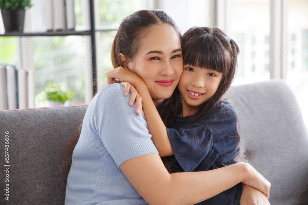 Portrait of asian daughter kissing her beautiful happy mother in living room. Portrait of asian daughter kissing her beautiful happy mother in living room.