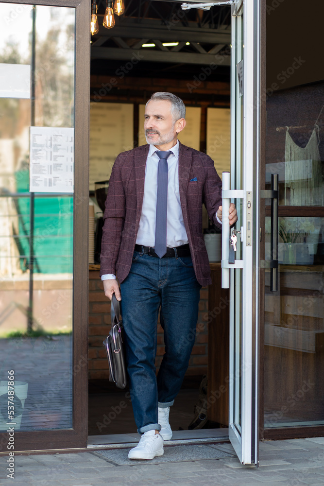 Confident good-looking man in the entrance of the street cafe Confident good-looking man in the entrance of the street cafe