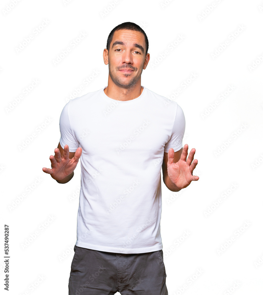 Doubtful young man doing a gesture of keep calm Doubtful young man doing a gesture of keep calm